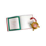 A gold ornament that looks a bit like a compass on a red hanger. There is a QR code in the center to scan for videos, displayed next to a red bound journal that says "Santa's Kindness Journal", displayed open to show inner pages.